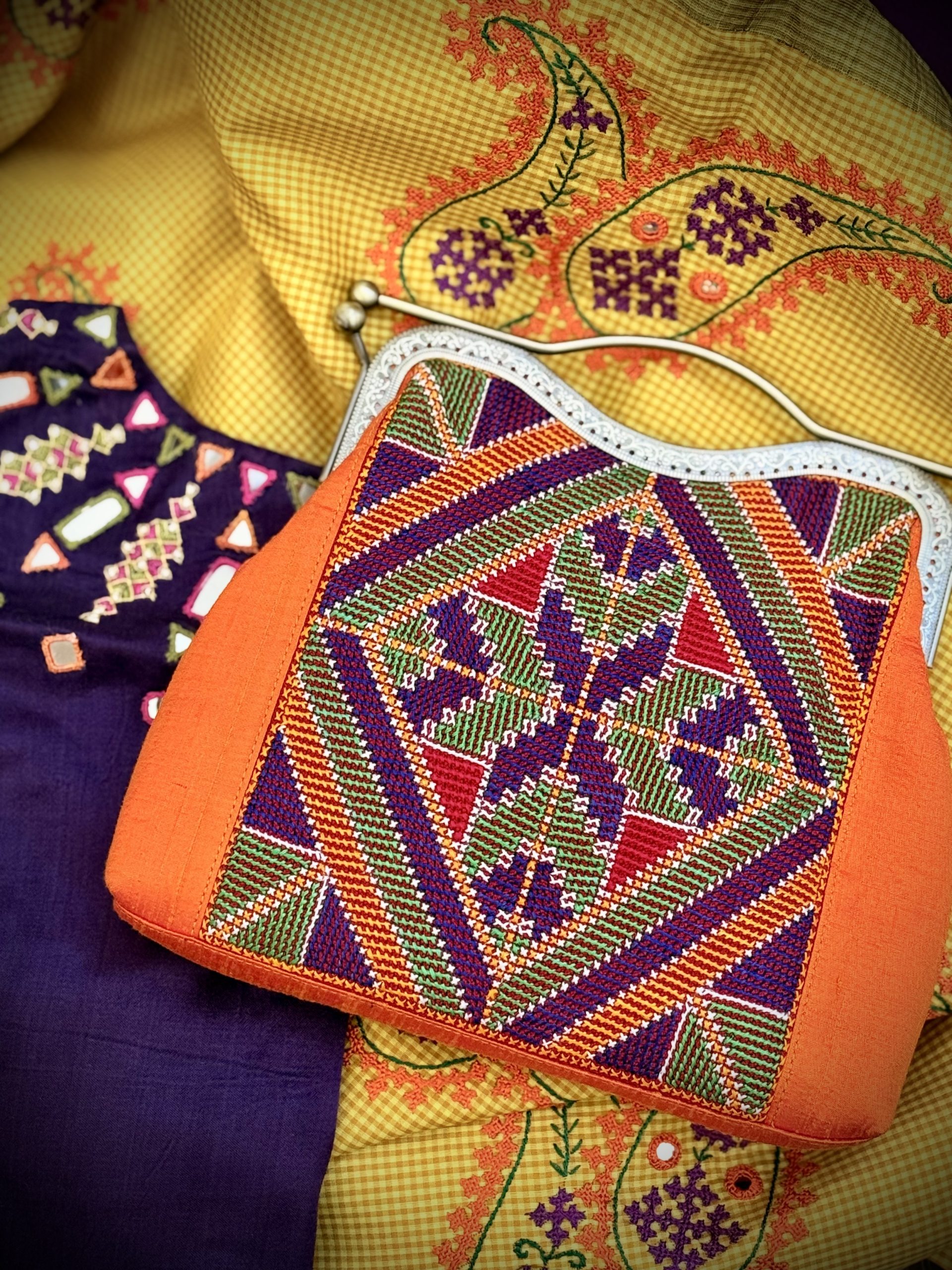 Orange purse with purple and green Kutchi embroidery and antique metal frame