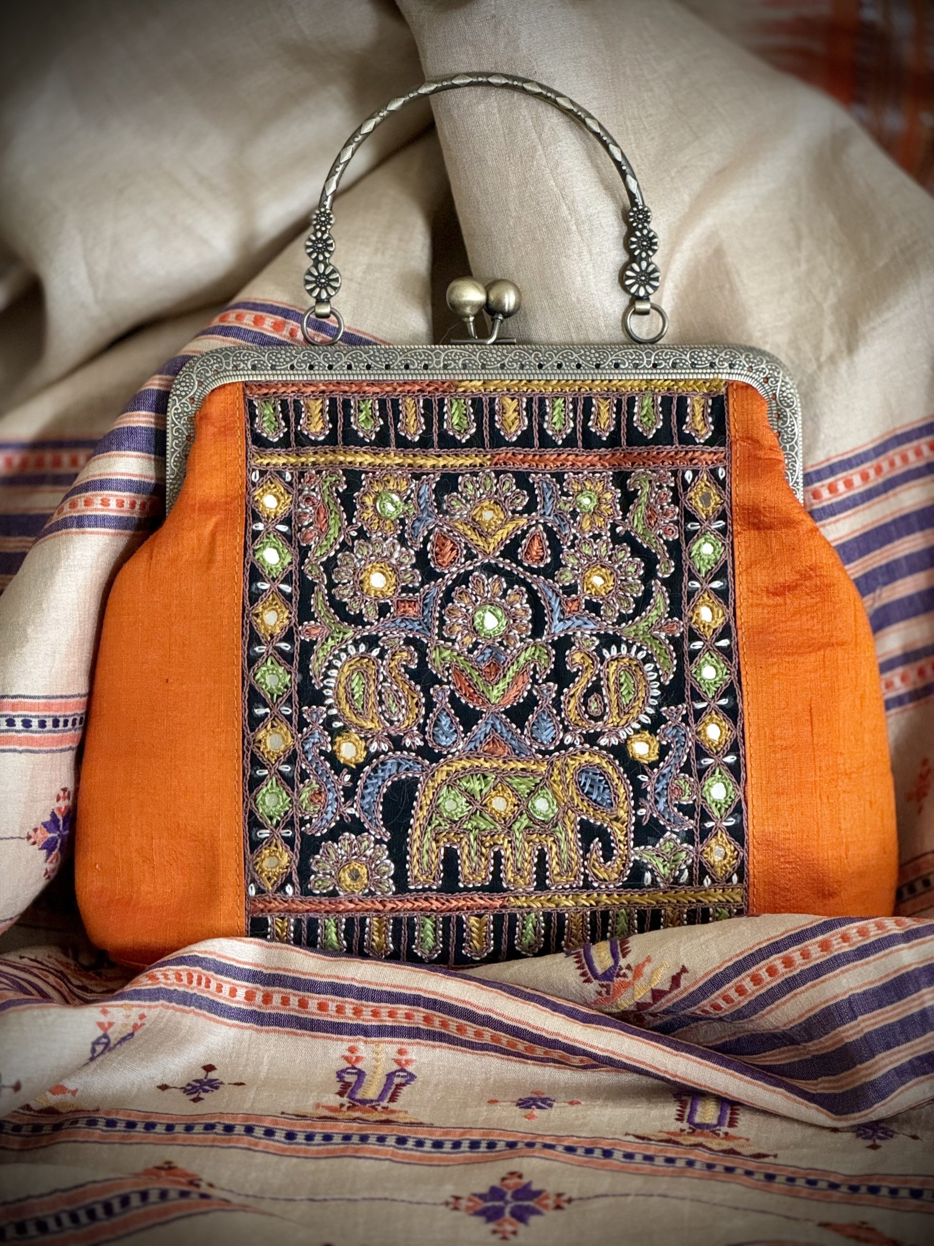 Orange Kutchi embroidered handbag with elephant and floral motifs