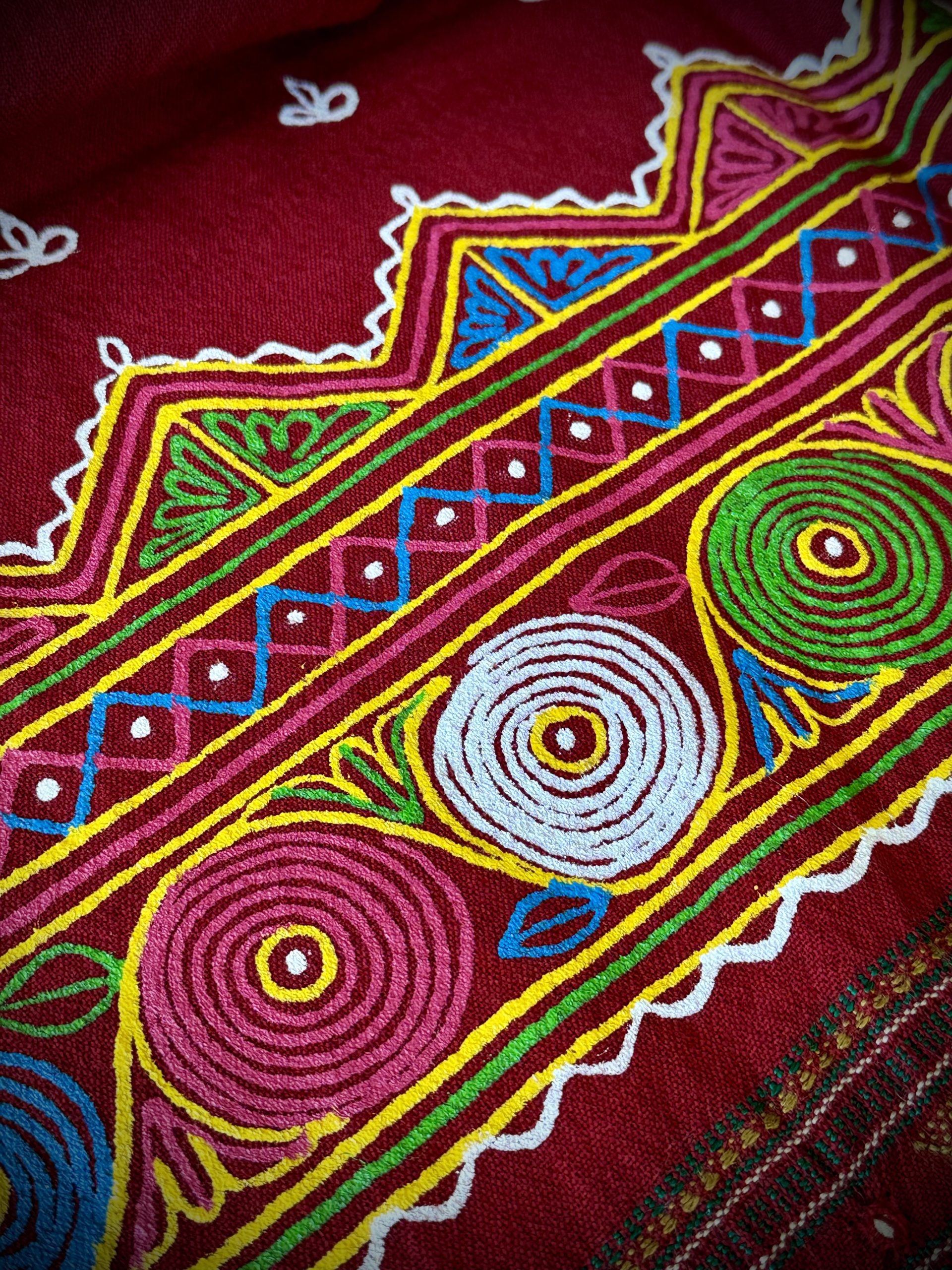 Traditional Rogan art hand-painted on red fabric