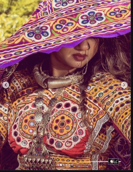 Model wearing a colourful embroidered Kutch ensemble and traditional jewellery