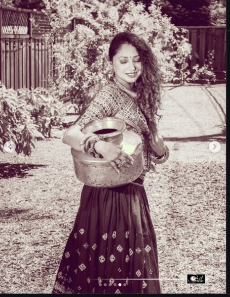 Cultural portrait carrying a traditional vessel in a Kutch ensemble